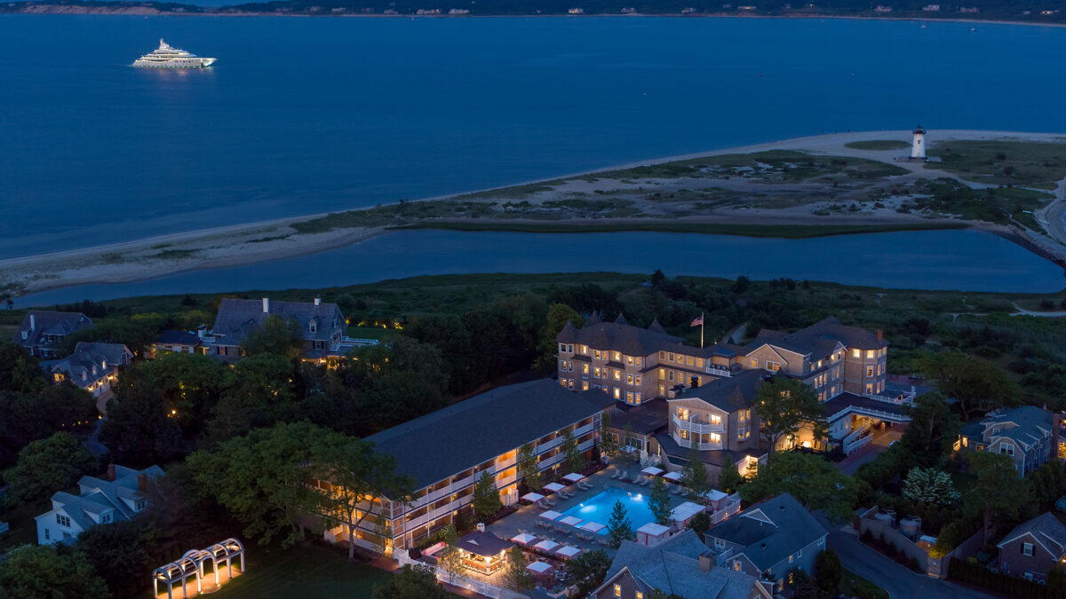 Aerial view of Harbor View Hotel on Martha's Vineyard at night with a yacht in the harbor.