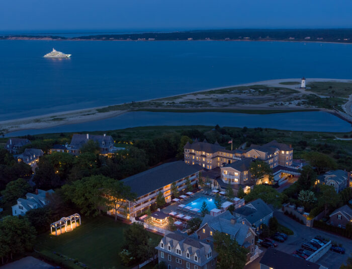 Aerial view of Harbor View Hotel on Martha's Vineyard at night with a yacht in the harbor.